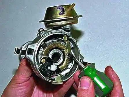 Ремонт датчика распределителя зажигания ВАЗ-2107 Поддев тонкой отверткой, снимаем запорную шайбу тяги вакуумного регулятора