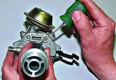 Ремонт датчика распределителя зажигания ВАЗ-2107 Отворачиваем два винта крепления вакуумного регулятора опережения