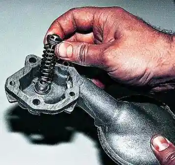 Снятие и разборка масляного насоса ВАЗ-2107 Извлекаем из патрубка редукционный клапан с пружиной