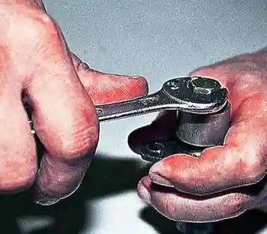 Утапливаем плунжер в корпус натяжителя до упора и, удерживая его в таком положении, затягиваем колпачковую гайку