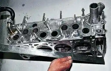 Металлической линейкой проверяем привалочную плоскость головки блока цилиндров