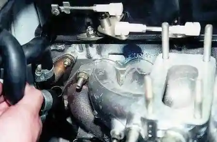 Снимаем с отводящей трубы шланг отвода охлаждающей жидкости 