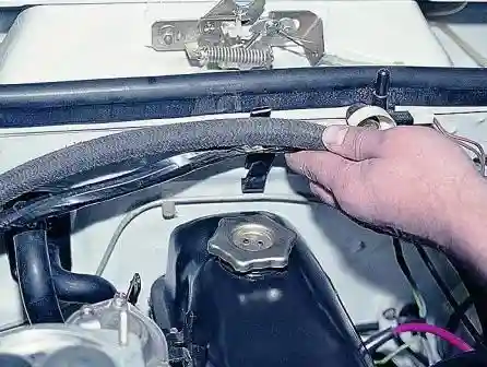 Разжимаем держатель и освобождаем шланг вакуумного усилителя тормозов и жгут проводов