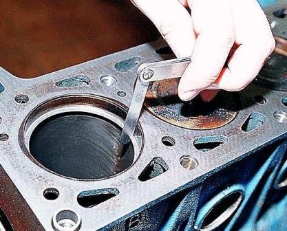 Проверьте плоским щупом зазор в замке колец, установив кольцо в цилиндр на глубину около 50 мм