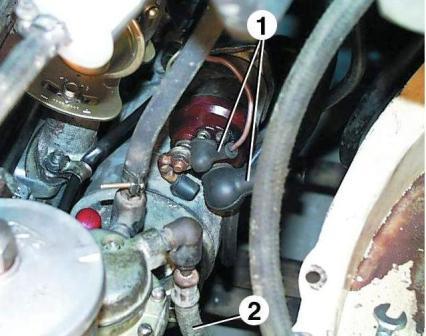 Disconnect the wires from the starter by removing the rubber protective caps 1. Disconnect the fuel line 2 from fuel pump