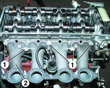 Unscrew nuts 1 and remove intake pipe 2 together with injectors and fuel lines