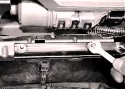 Отверните две гайки крепления распорки к кузову автомобиля