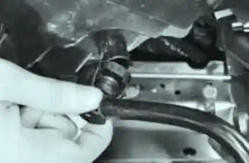 приподняв фильтр, отсоедините от штуцера на его корпусе шланг системы 