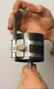 Специальным приспособлением сожмите поршневые кольца на поршне