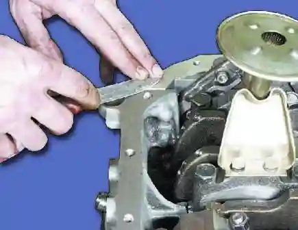 Удалите герметик, выдавленный при установке задней крышки на сопрягаемую поверхность масляного поддона